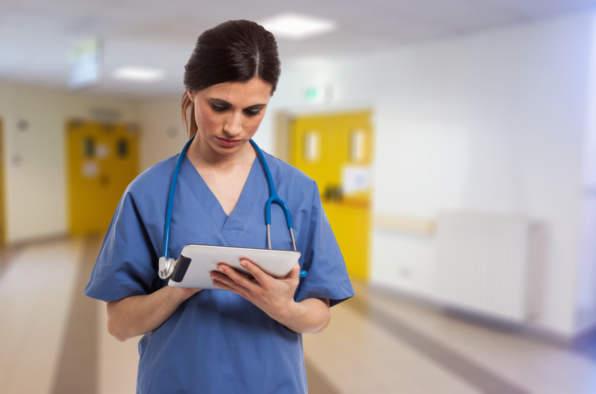 Visual representation of healthcare time and attendance software in a workforce or time tracking context, with a nurse looking at a sheet in front of her measuring something