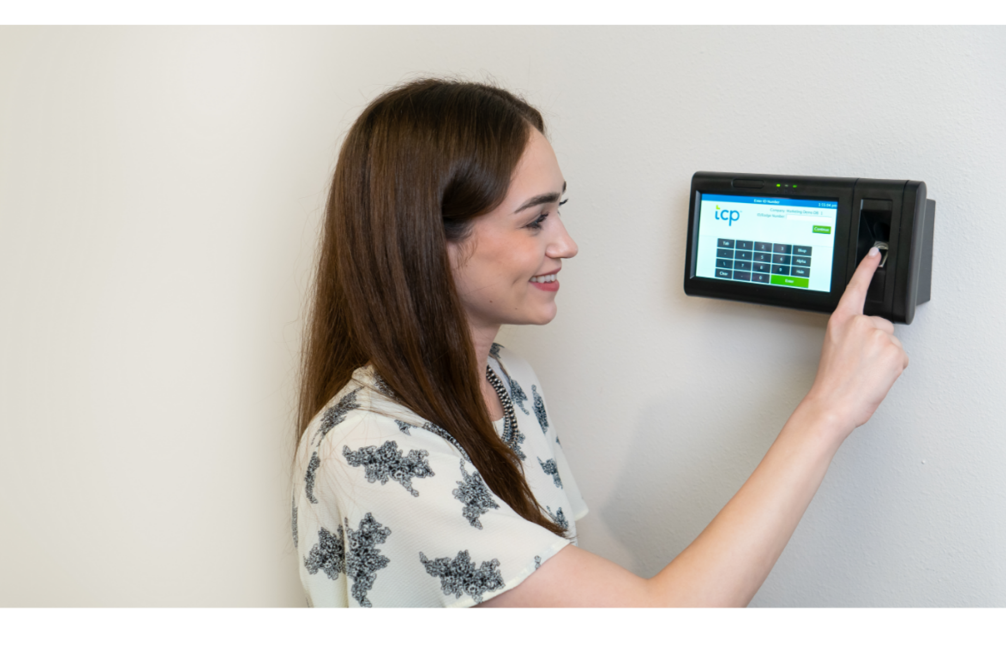 A woman pointing to a TCP clock-in hardware representative of different employee time clock options including biometric and mobile