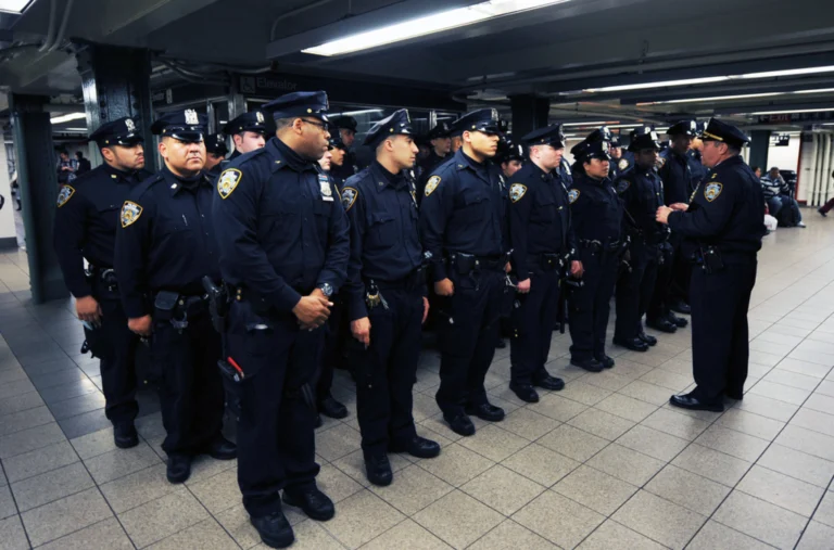 Police officers standing in a unit formation, listening to a captain that is instructing them about their scheduling, representing how to schedule employees in public safety