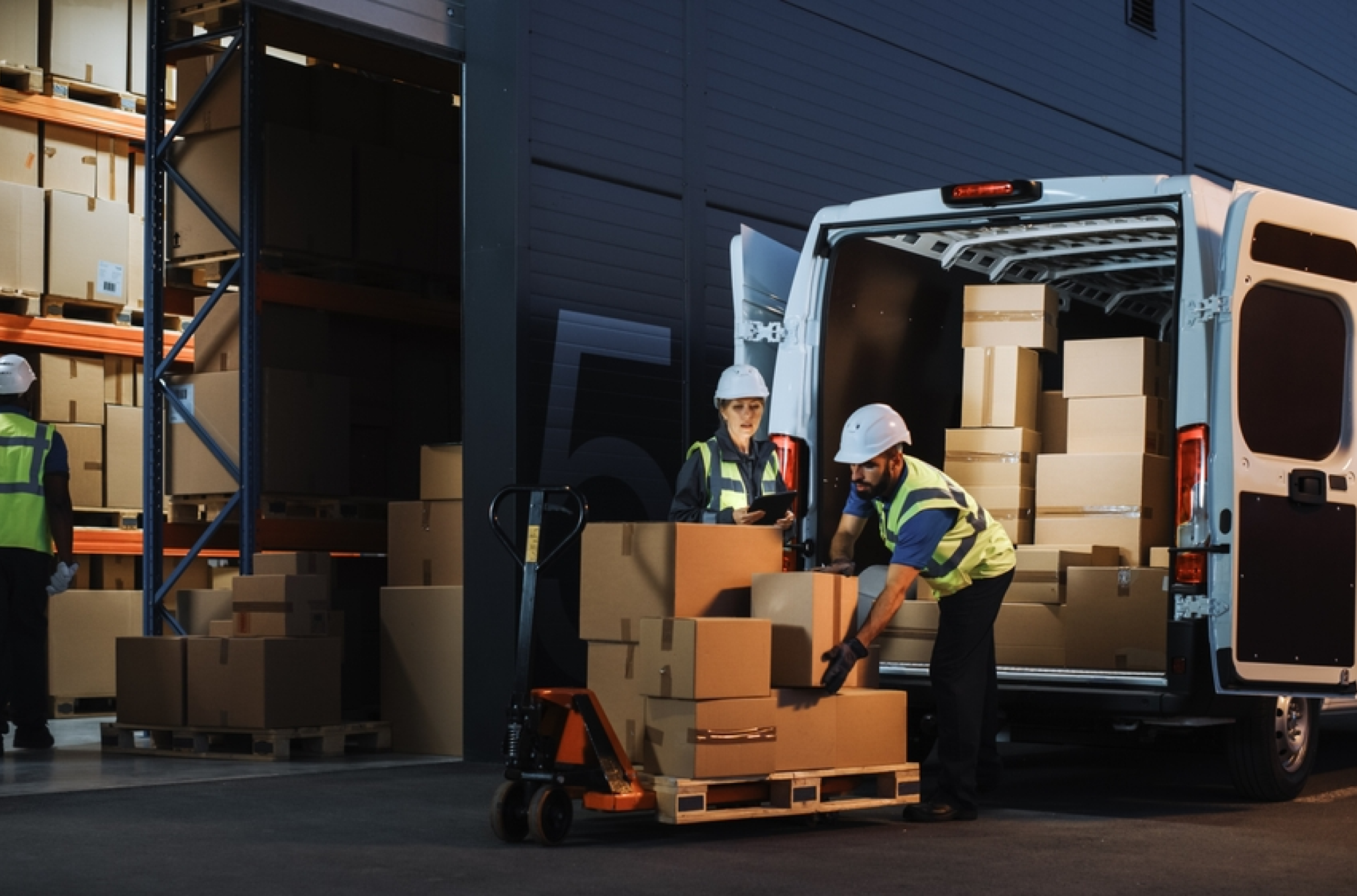Visual representation of overtime pay with two manufacturing employees loading freight into the back of a van