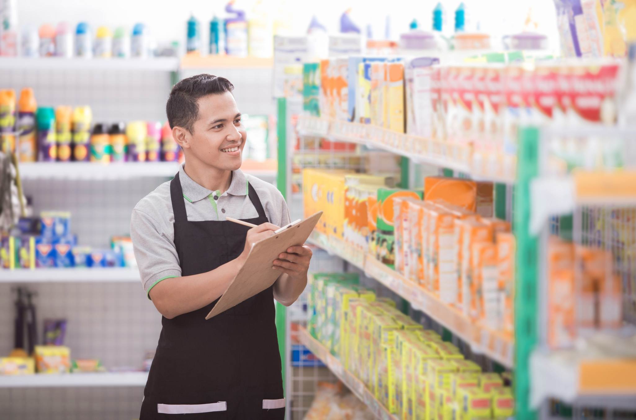 Visual representation of workforce management through an employee checking stock in a grocery store, with an approving grin on his face as he works