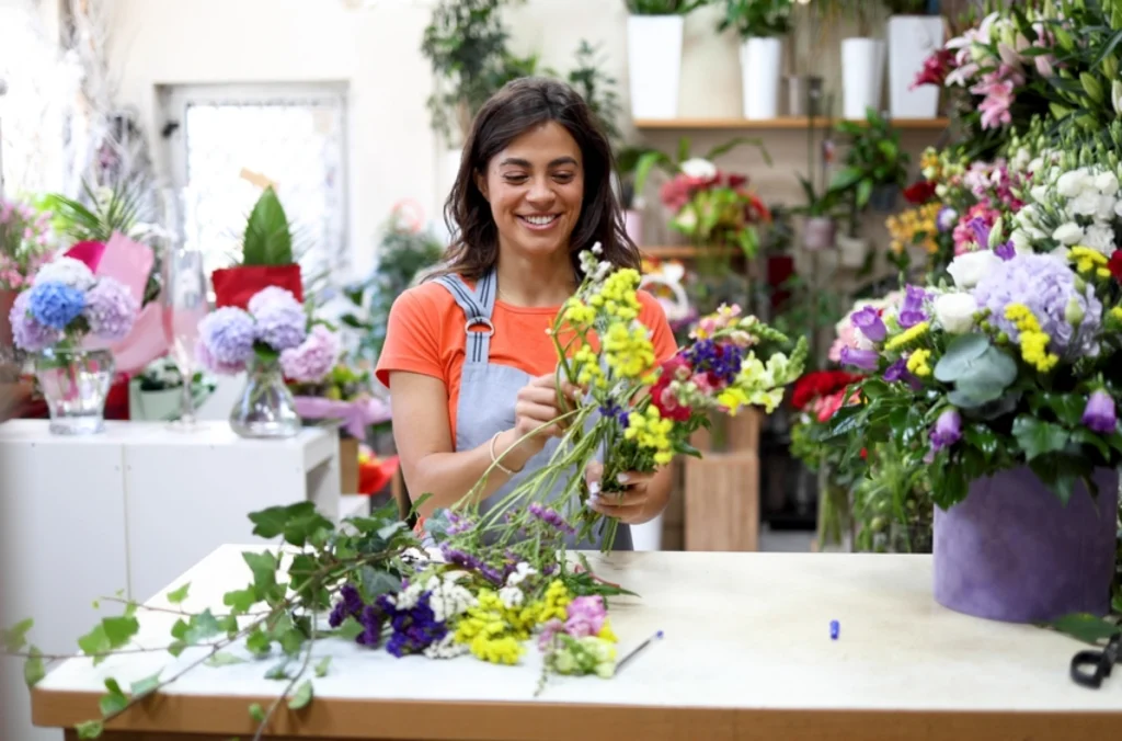 A florist woman pruning her yellow flowers, as a representation of an hourly vs. salaried employee in a workforce