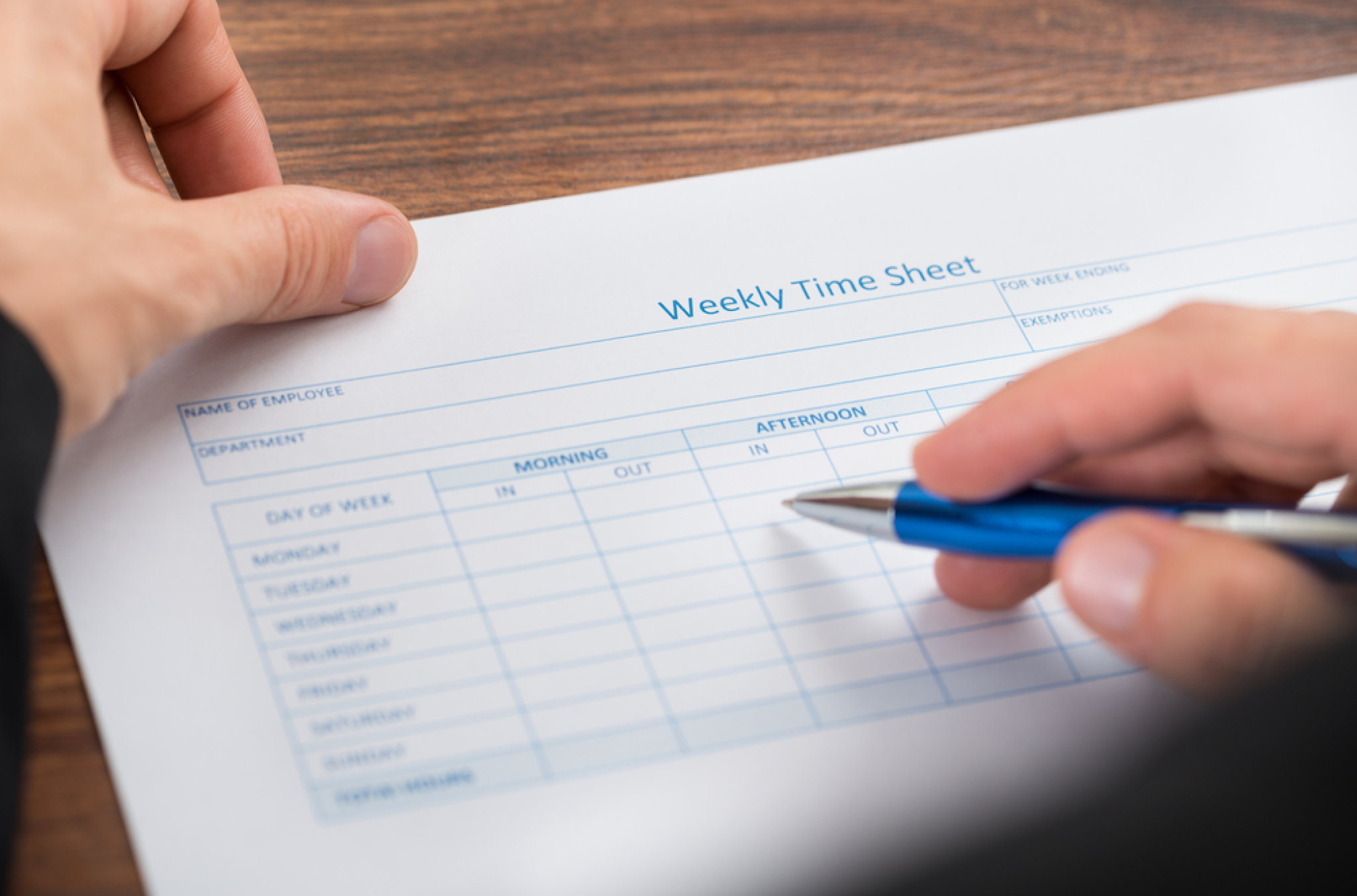 paper timesheet with grids, illustrating the manual vs automated payroll debate because of the physical work portrayed in the image