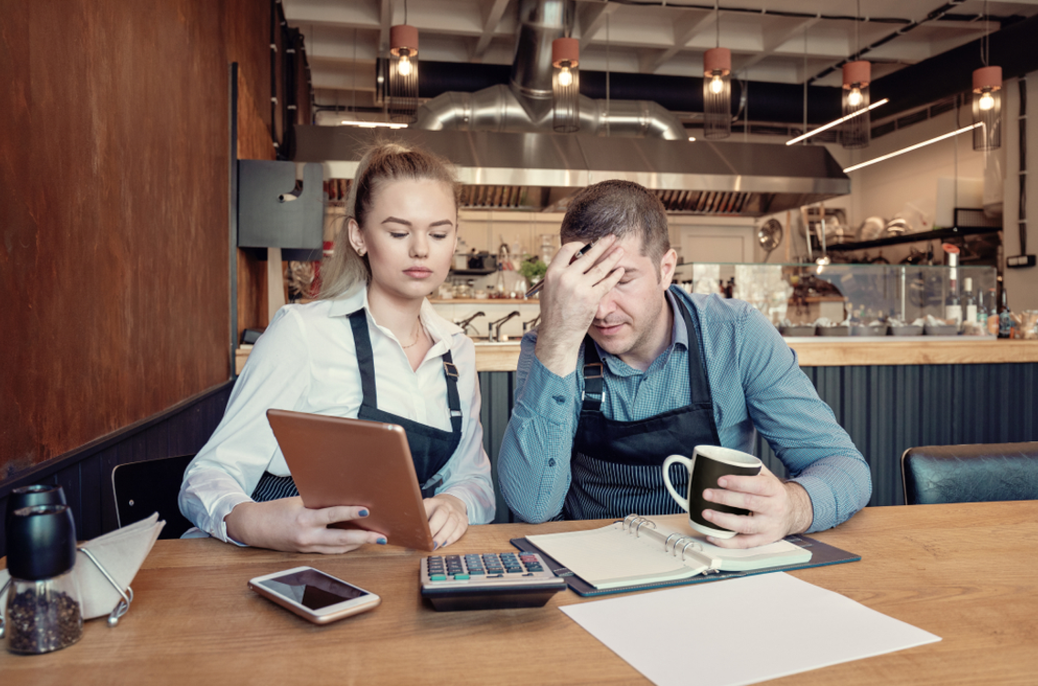 A female employee and her manager reviewing a schedule, looking as if they committed one of the top employee scheduling mistakes