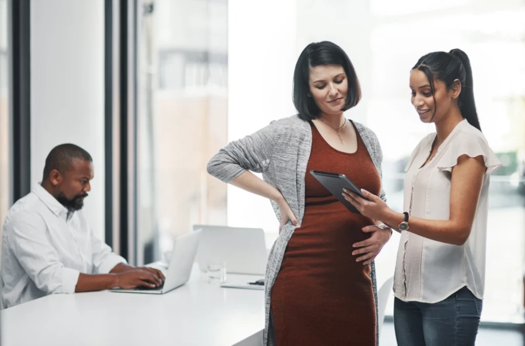 Employee managing or requesting leave in a digital system in front of her supervisor, related to leave management system software