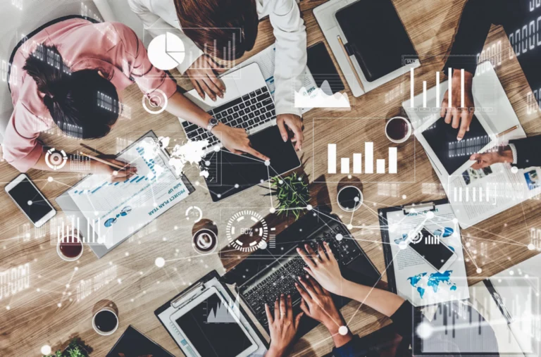 An overhead shot of several devices, like laptops and tablets, with data overlays and charts, demonstrating the complexity of enterprise resource planning