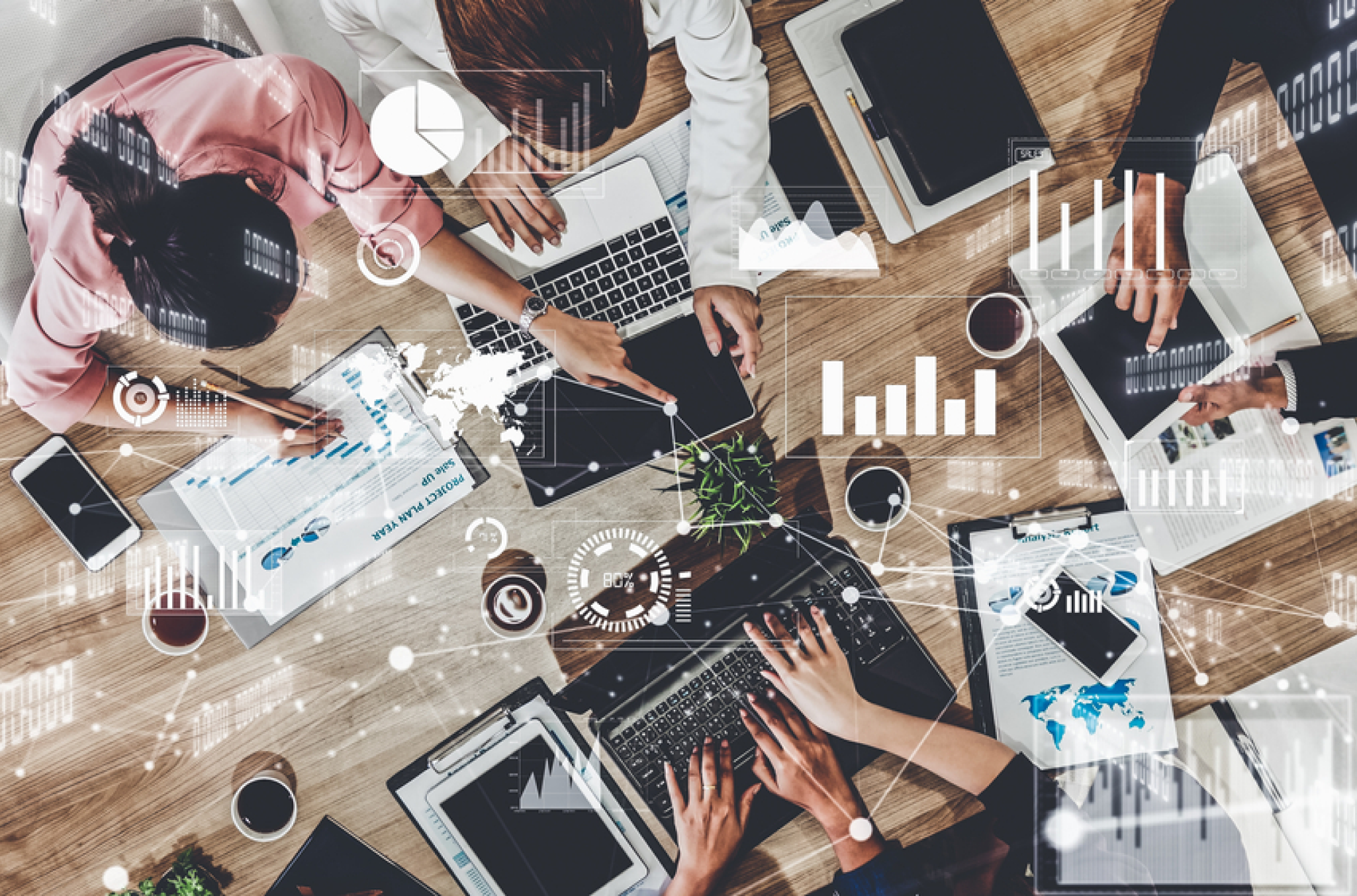 An overhead shot of several devices, like laptops and tablets, with data overlays and charts, demonstrating the complexity of enterprise resource planning