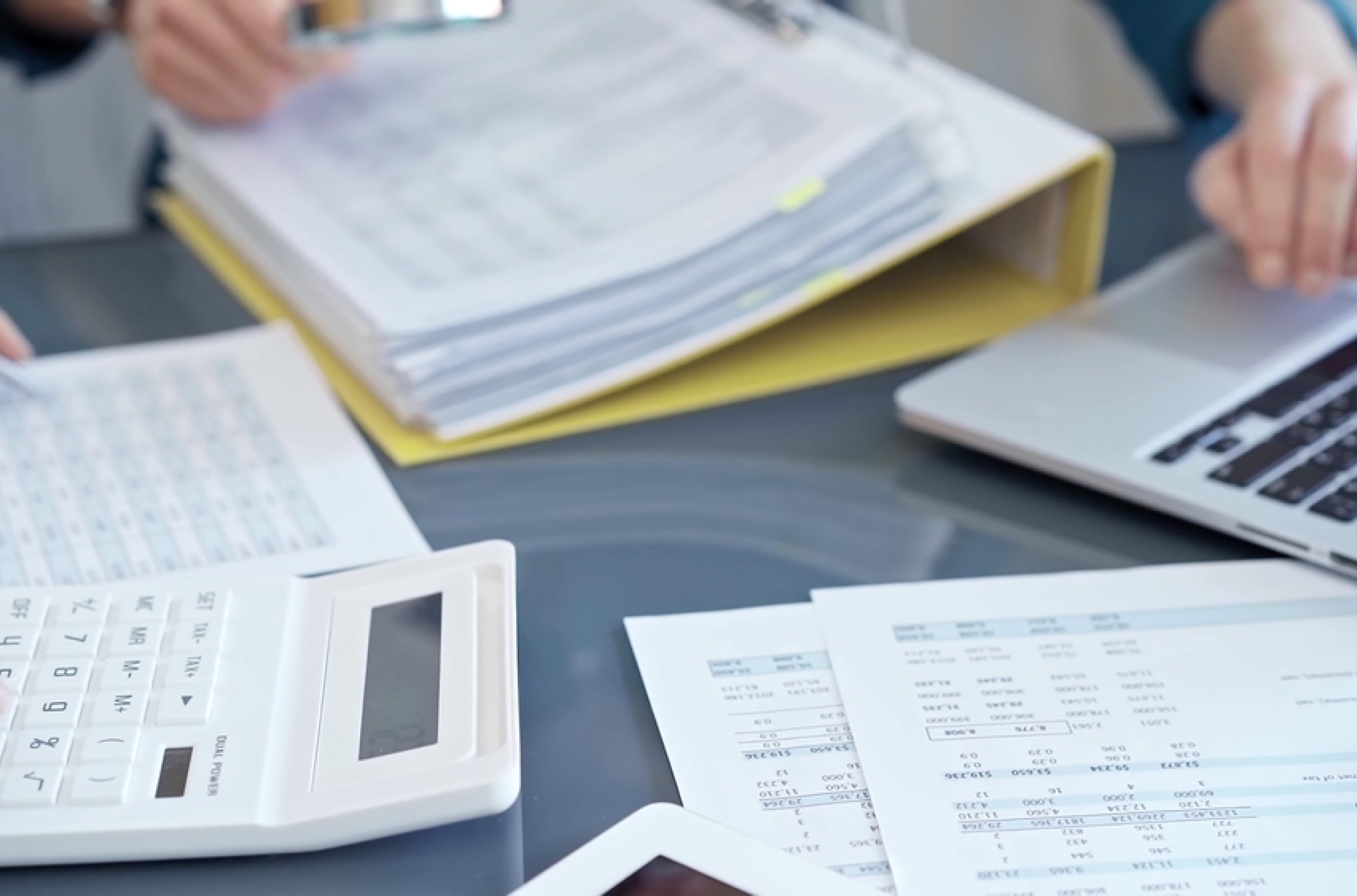 A pile of tax paperwork and a list of payroll tax responsibilities