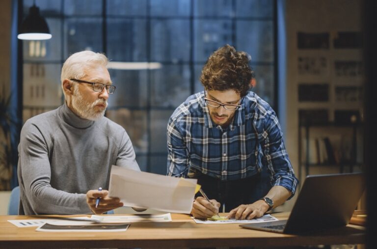 A senior executive and manager looking at paperwork that covers labor laws in the U.S.